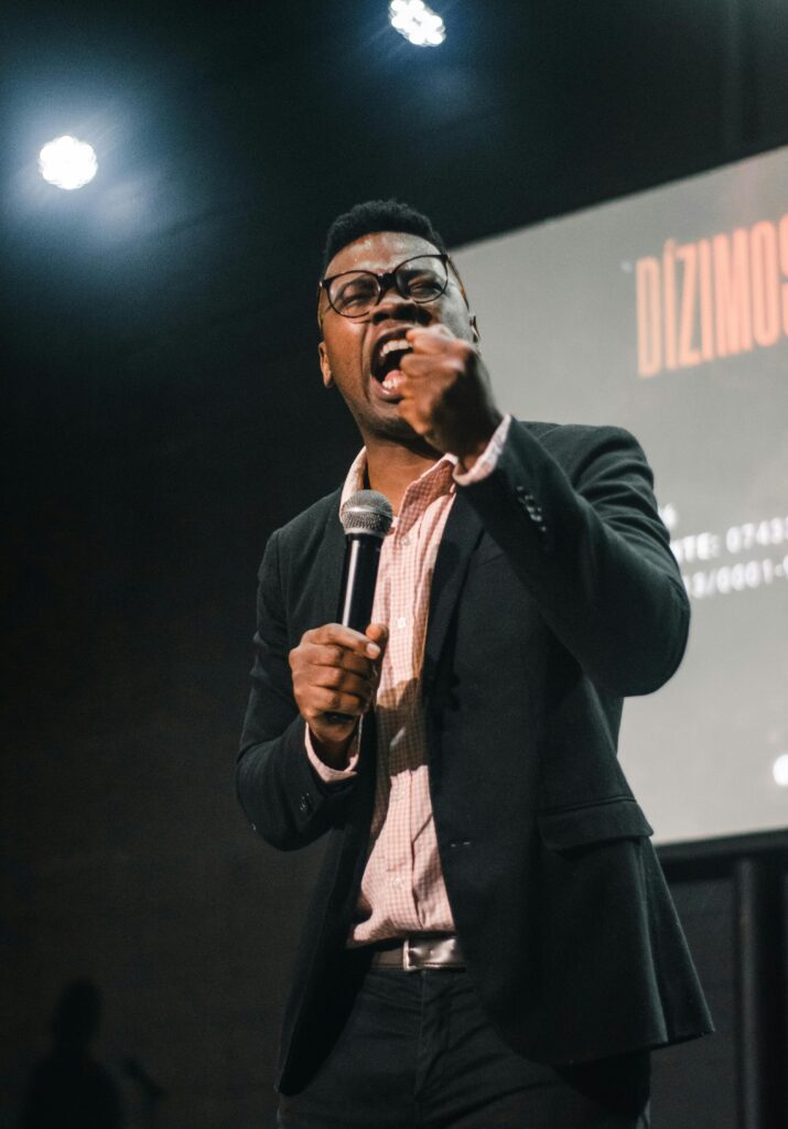Confident man speaking passionately at an indoor event. Perfect for business and motivational themes.